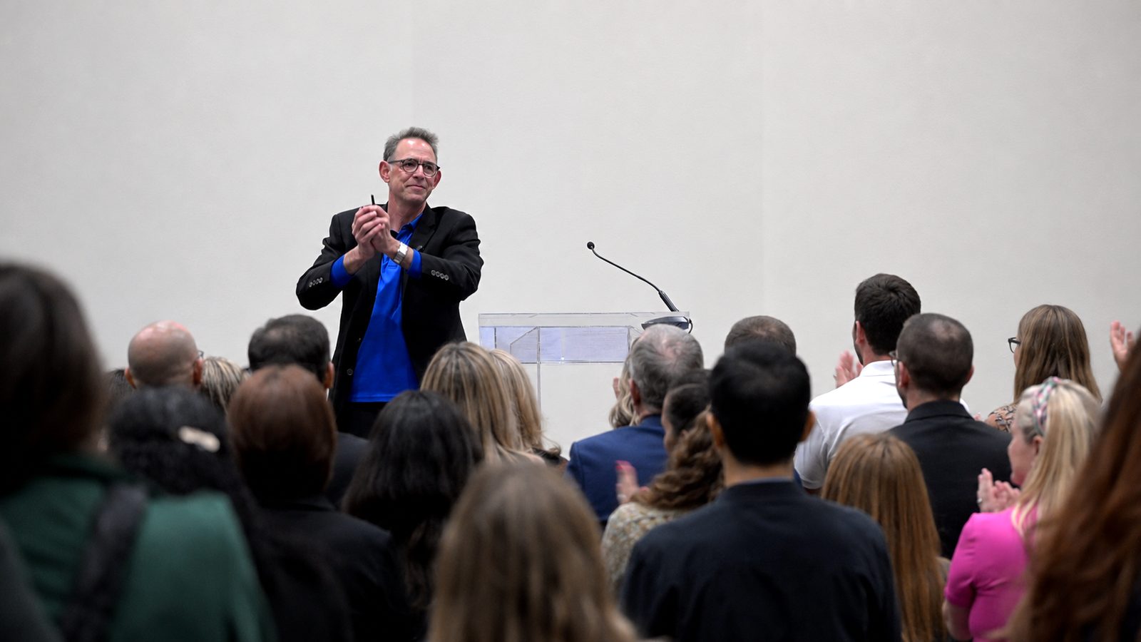 David Suson applauding a standing audience at the end of his keynote
